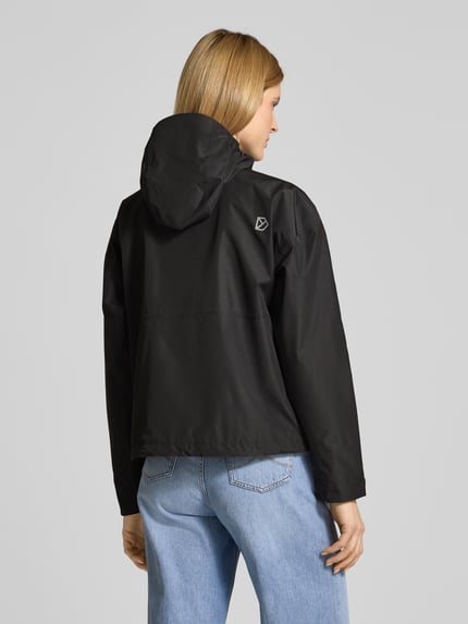 Modelka nosi czarną kurtkę z kapturem Didriksons Jacke mit Pattentaschen Modell 'MILENA', prosty krój, logo, widok z tyłu, Ganzkörperansicht Rückansicht. Długość tyłu w rozmiarze 36: 60 cm, szerokość ramion w rozmiarze 36: 60 cm, szerokość klatki piersiowej w rozmiarze 36: 55 cm, długość rękawów w rozmiarze 36: 66 cm.
