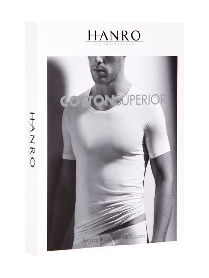 Männermodel trägt T-Shirt mit geripptem Rundhalsausschnitt von Hanro, Baumwoll-Elasthan-Mix, Slim Fit, helle Farbe, Nahaufnahme Oberkörper.