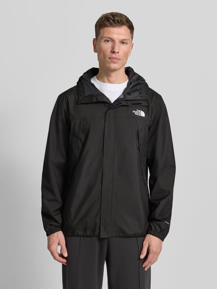 Männermodel trägt schwarze Regular Fit Jacke mit Logo-Print Modell 'Quest' von The North Face, glatte Textur, Ganzkörperansicht von vorne. Damen Jacke, Kapuze, Reißverschluss, Rückenlänge 100 cm, Schulterbreite 46 cm, Brustweite 58 cm, Ärmellänge 68 cm.