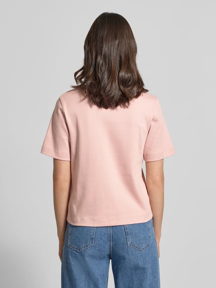 Kobiece modelka nosi T-shirt mit Rundhalsausschnitt und Label-Stitching od Oui z bawełny, krój regular fit, długość tyłu w rozmiarze 36: 56 cm, widok całej sylwetki z tyłu.