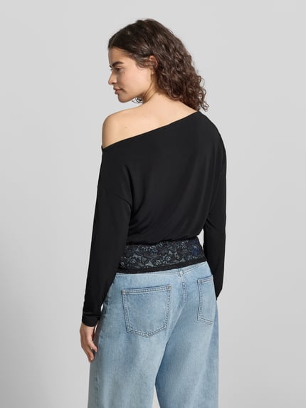 Vrouwenmodel draagt shirt met lange mouwen met asymmetrische hals en kant, model 'Mirelin' van Gina Tricot, materiaalmix met stretch, nauwsluitend model, zwarte kleur, ruglengte bij maat S 52 cm, detailopname rugaanzicht.
