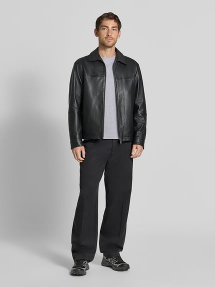 Mannelijk model draagt Slim Fit Longsleeve uit puur katoen Model 'Enil' van DRYKORN met structuurpatroon en ronde hals, kleur zwart, herenshirt met lange mouwen, volledige lichaamsaanzicht van voren. Ruglengte maat M 67 cm, mouwlengte 69 cm.