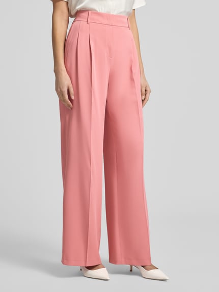 Frauenmodel trägt Straight Fit Stoffhose mit Bügelfalten von Christian Berg Woman Selection in Rosa, mit Gesäßtaschen, Nahaufnahme Oberkörper.