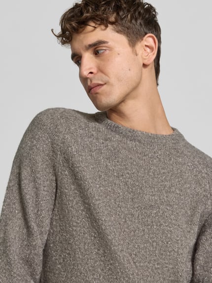 Männermodel trägt Regular Fit Pullover mit Woll-Anteil von Closed, melierte Strick-Optik in Grau, Nahaufnahme Oberkörper. Material-Mix, Rundhalsausschnitt, elastische Abschlüsse.