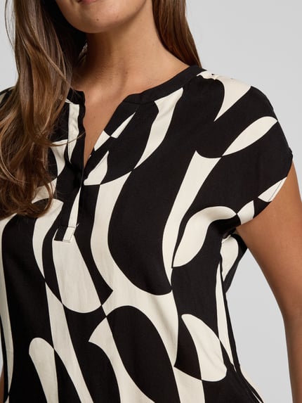 Vrouwenmodel draagt Regular Fit Blouse van viscose met V-hals model 'CHANISE' van Soyaconcept, allover zwart-wit dessin, close-up bovenlichaam.