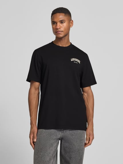 Männermodel trägt Herren T-Shirt mit Label-Print Modell 'Brady whop' von Les Deux, schwarz, Reine Baumwolle, Gerader-Schnitt, Nahaufnahme Oberkörper.