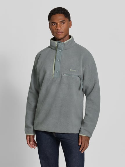 Männermodel trägt Fleecepullover mit Label-Patch Modell 'Helvetia™ II' von Columbia in Grau, gerade Form, Ganzkörperansicht von vorne.