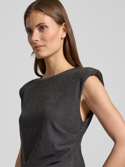 Kobieta modelka nosi bluzkę Blusentop mit Glitter-Effekt Modell 'NURA' od YAS, mieszanka materiałów z dodatkiem streczu, krój regular fit, prążkowany okrągły dekolt, efekt błyszczący, długość tyłu 60 cm dla rozmiaru 36, kolor ciemny, widoczne lekkie połyskujące drobinki, zbliżenie na górną część ciała, ujęcie z przodu.