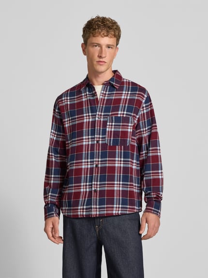 Männermodel trägt Regular Fit Freizeithemd aus Flanell mit Kentkragen von REVIEW, kariertes Muster in Rot, Blau und Weiß, Ganzkörperansicht von vorne. Rückenlänge 74 cm, Schulterbreite 42 cm, Ärmellänge 70 cm, reine Baumwolle, Allover-Look, Brusttasche.