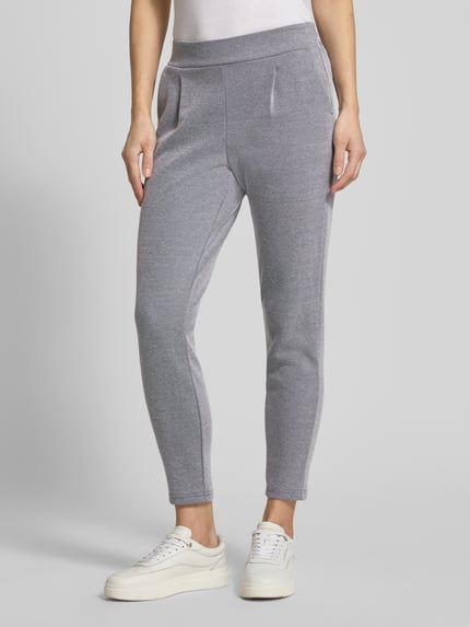 Frauenmodel trägt Slim Fit Stoffhose mit elastischem Bund Modell 'Kate' von ICHI aus Baumwoll-Mix, graue Struktur, Paspeltaschen, Ganzkörperansicht von vorne.