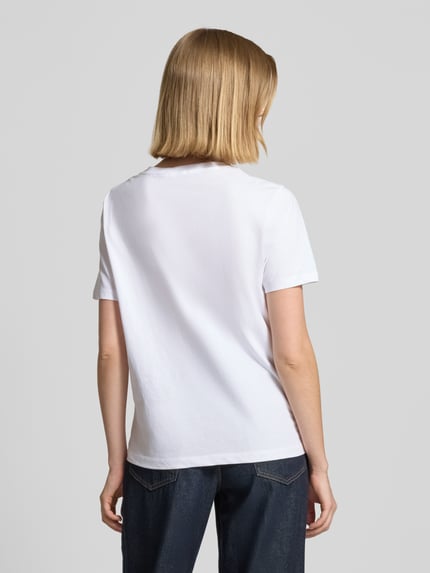 Kobiece model prezentuje damski t-shirt z bawełny od B.Young, model 'SOBBE', nadruk z motywem, krój regular fit, okrągły dekolt, długość tyłu w rozmiarze S: 60 cm, biała gładka faktura, widok całej sylwetki od tyłu.