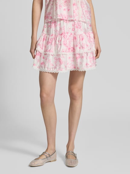 Frauenmodel trägt ausgestellten Mini-Rock aus Viskose-Mix mit floralem Allover-Muster von Vero Moda, Nahaufnahme Unterkörper.