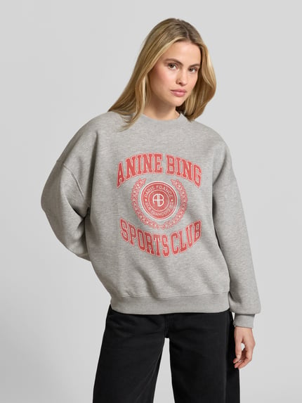 Vrouwenmodel draagt Oversized Sweatshirt met katoenmix van Anine Bing, grijs met rode labelprint, ribboorden, Materiaalmix, Ganzkörperansicht van voren.
