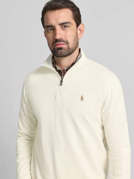 Męski model nosi Bluza z wyhaftowanym logo od Polo Ralph Lauren, mieszanka bawełny i wiskozy, luźny krój, stójka, prążkowane wykończenia, kremowy, zamek błyskawiczny, długość tyłu 69 cm, długość rękawa 64 cm, nahaufnahme górnej części ciała.