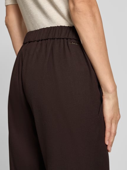 Kobieta nosi Regular Fit Gerade Hose mit Viskose-Anteil Modell 'Sue' von TONI w kolorze ciemnobrązowym, tekstura gładka, detal tylnej części, damska Gerade Hose od TONI, zbliżenie na dolną część pleców