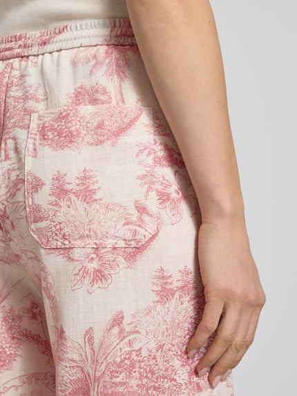 Frauenmodel trägt Stoffhose mit elastischem Bund Modell 'VIOLETTA' von SEDUCTIVE im Allover-Look, Detailaufnahme, Damen, Relaxed-Fit, Bundweite 42 cm, Innenbeinlänge 79 cm bei Größe 36, zartes Rosa mit floralen Strukturen.