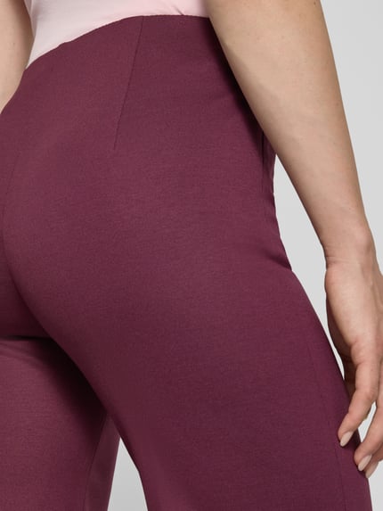 Männermodel trägt Hose aus Viskose-Mix mit Reißverschlusstaschen von Marc Cain, kolor bordowy, krój regular fit, detal bioder, Nahaufnahme Hüfte