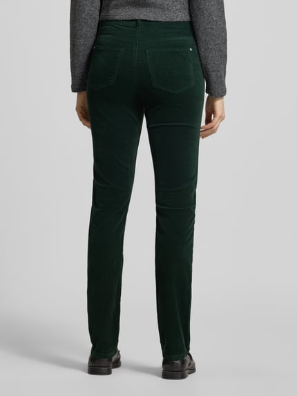 Frauenmodel trägt zielone spodnie materiałowe 'Slim Fit Stoffhose aus elastischem Baumwoll-Mix' von Christian Berg Woman z mieszanki bawełny, krój slim fit, szlufki na pasek, 5 kieszeni, zapięcie na guzik i zamek błyskawiczny, szerokość w rozmiarze 36/32: 38 cm, długość wewnętrzna nogawki w rozmiarze 36/32: 82 cm, widoczne kieszenie z tyłu, gładka faktura, całkowity widok sylwetki z tyłu.