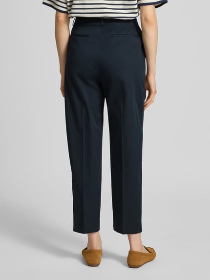 Frauenmodel trägt Tapered Chino aus Baumwoll-Mix Modell 'TECARINO2' von BOSS, Optik: Unifarben, Passform: Tapered, Ganzkörperansicht Rückansicht
