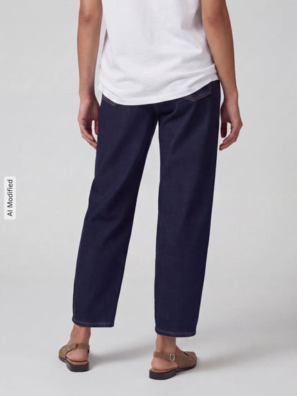 Frauenmodel trägt Regular Fit Barrel Jeans aus Baumwoll-Mix Modell 'ELLY' von ANGELS in Dunkelblau, Damen Barrel Jeans, Ganzkörperansicht Rückansicht, KI-modifiziertes Bild.