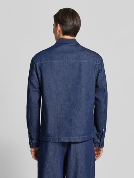 Männermodel trägt Regular Fit Hemdjacke in Denim-Optik von Scotch & Soda, dunkles Blau, Kentkragen, Aufgesetzte Taschen, Rückenansicht.
