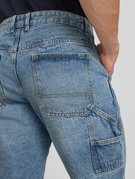 Mężczyzna nosi Shorts mit Kontrastnähten Modell 'Mito' od Redefined Rebel, bawełna, krój regular fit, niebieski, tekstura dżinsu, detal tyłu, Szerokość w rozmiarze M: 44 cm, długość wewnętrzna nogawki w rozmiarze M: 28 cm, detal tyłu