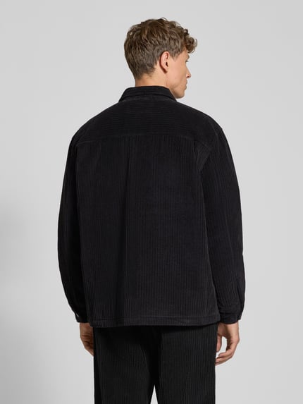 Männermodel trägt Regular Fit Hose mit seitlichen Eingrifftaschen von Lacoste aus Cord, unifarben, Struktur, Ganzkörperansicht Rückansicht.