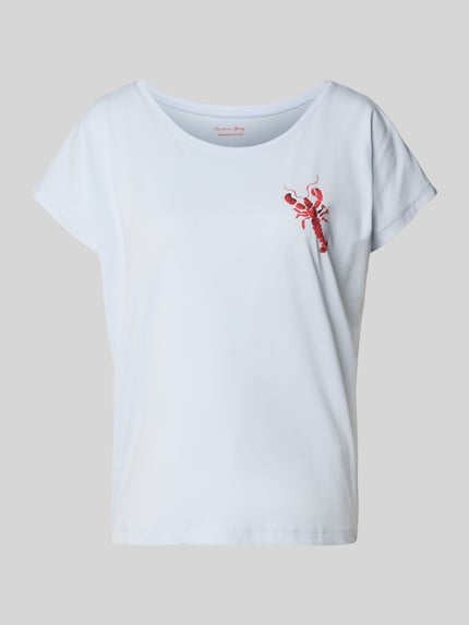 Frauenmodel trägt Pyjama-Oberteil mit Motiv von Christian Berg Woman, hellblau, weicher Baumwoll-Modal-Mix, Rundhalsausschnitt, Regular Fit, Motiv auf Brust, Ganzkörperansicht von vorne.