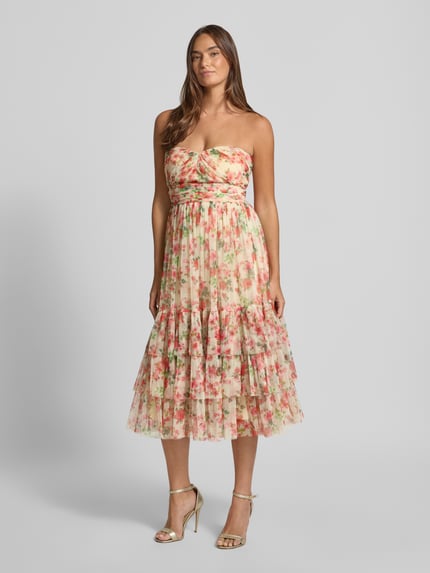 Frauenmodel trägt Midikleid mit floralem Allover-Print von LACE & BEADS in zarten Rosatönen, tailliert, mit Rüschen und Falten, schulterfrei, Ganzkörperansicht von vorne.