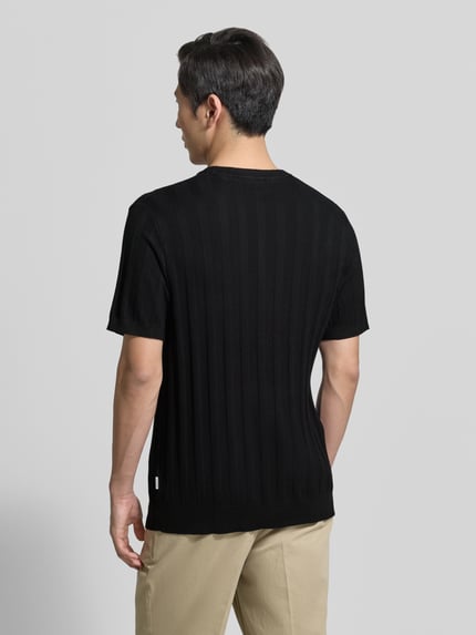 Mannmodel draagt gebreid shirt uit viscosemix met riblook en ronde hals van Lindbergh, regular fit, ruglengte maat M 69 cm, mouwlengte 24 cm, geheel in zwart, structuur zichtbaar, ganzkörperansicht rückansicht.