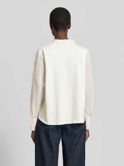 Kobieta modelka nosi Relaxed Fit Bluse mit Schnürung von Marc Cain z bawełny, wzór na całej powierzchni, wiązanie, długość tyłu 59 cm, długość rękawów 60 cm, widok całej sylwetki z tyłu.