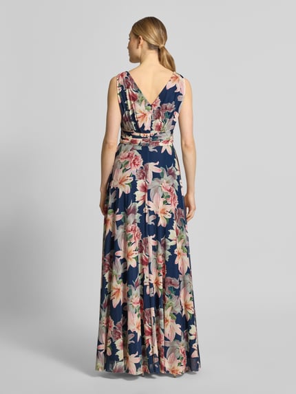 Frauenmodel trägt Maxikleid mit V-Ausschnitt und Gehschlitz von Christian Berg Cocktail, floraler Allover-Look, Material-Mix mit Stretch-Anteil, A-Linie, Rückenlänge 150 cm, Ganzkörperansicht Rückansicht.
