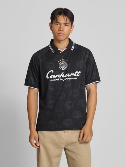Männermodel trägt Funktionsshirt mit Logo Modell 'Terrace' von Adidas, Schwarz mit weißem Logo, Regular Fit, Rundhalsausschnitt, Ganzkörperansicht von vorne, Herren Funktionsshirt, Rückenlänge bei Größe M: 71 cm.