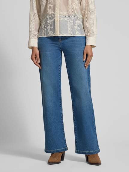 Vrouwenmodel draagt Flared Jeans mit Eingrifftaschen van Jake*s Collection in used-look, blauwe denim, flared cut, vooraanzicht, detailopname onderlichaam.
