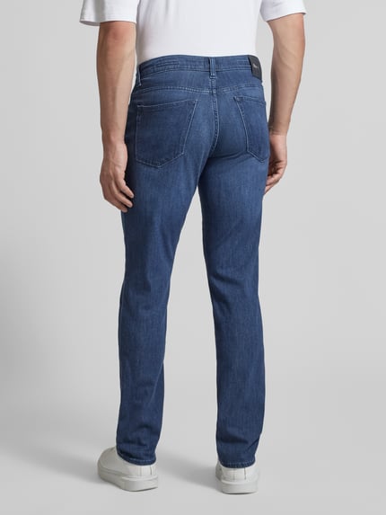 Männermodel trägt Slim Fit Jeans mit Seiden-Anteil Modell 'Chuck' von BRAX, klassische blaue Farbe, 5-Pocket-Design, Ganzkörperansicht Rückansicht. Elastischer Baumwoll-Mix mit Viskose-Seiden-Anteil, Bundweite 44 cm, Innenbeinlänge 81 cm.