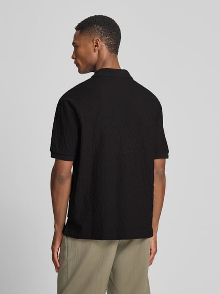 Männermodel trägt Regular Fit Poloshirt mit Strukturmuster von ARMANI EXCHANGE aus reiner Baumwolle, Rückenlänge 68 cm, Ganzkörperansicht Rückansicht