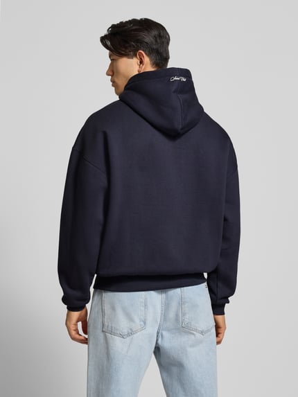 Männermodel trägt Hoodie mit Kapuze von PROHIBITED in Dunkelblau, gerippte Abschlüsse, lockerer Schnitt, Rückenlänge 69 cm, Ganzkörperansicht Rückansicht.