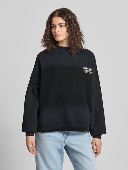 Modelka nosi Regular Fit Sweatshirt mit Logo-Print od ANOTHER COTTON LAB, mieszanka bawełny, stójka, elastyczne wykończenia, widok z przodu na całe ciało.