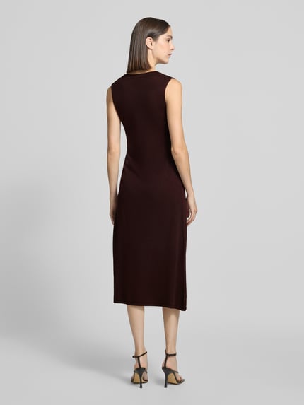 Frauenmodel trägt Strickkleid mit Wasserfall-Ausschnitt Modell 'SANTA' von MANGO in Dunkelbraun, Gerader Schnitt, Ganzkörperansicht Rückansicht.