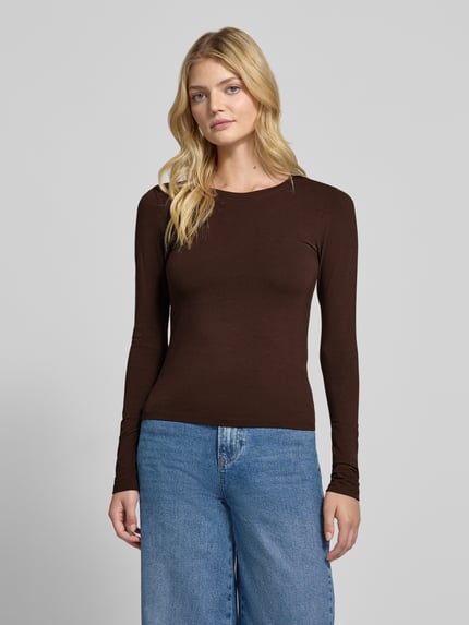 Frauenmodel trägt Slim Fit Basic Langarmshirt aus Baumwollmix von REVIEW, dunkles Braun, glatte Textur, Rundhalsausschnitt, Ganzkörperansicht von vorne, Damen Longsleeve, Baumwoll-Elasthan-Mix, Rückenlänge bei Größe S 51 cm.