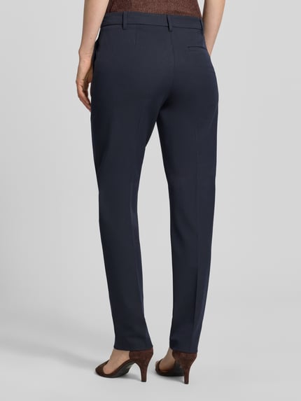 Männermodel trägt Hose mit Bügelfalten und Gesäßtasche von Christian Berg Woman Selection, mieszanka materiałów z dodatkiem wiskozy, krój regular fit, kanty, kieszeń z tyłu, szerokość w rozmiarze 36: 42 cm, długość wewnętrzna nogawki w rozmiarze 36: 80 cm, granatowy, gładka faktura, ganzkörperansicht rückansicht.