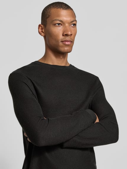 Männermodel trägt Strickpullover aus Wollmix Modell 'Bennino' von JOOP!, unifarben, Strickoptik, Nahaufnahme Oberkörper.