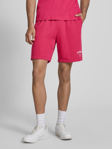 Männermodel trägt Sweatshorts mit Logo und elastischem Bund von CHAMPION in Pink, Baumwoll-Mix, Regular Fit, Nahaufnahme Oberschenkel.