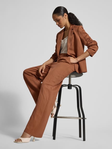 Frauenmodel trägt Stoffhose mit Eingrifftaschen und Gesäßleistentaschen von Jake*s Collection in Braun, Lyocell-Mix, Loose Fit, Ganzkörperansicht von vorne.