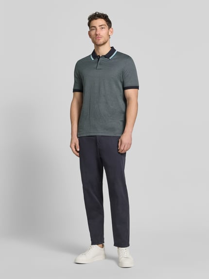 Mężczyźni model nosi Regular Fit Poloshirt mit Polokragen und kurzer Knopfleiste von bugatti z bawełny, detal z logo, długość tyłu w rozmiarze M 70 cm, Ganzkörperansicht von vorne.