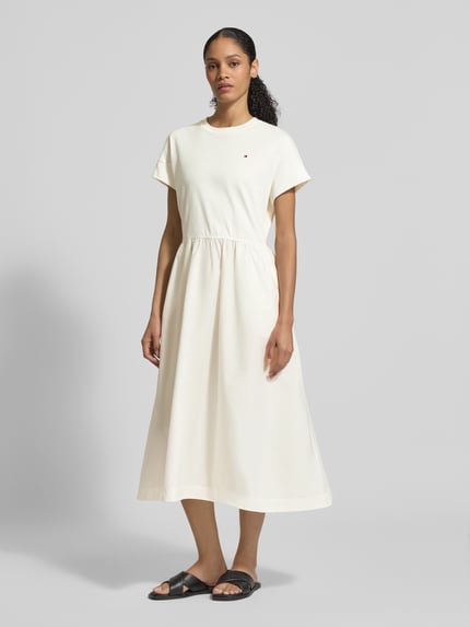 Vrouwenmodel draagt Ausgestelltes Freizeitkleid aus Material-Mix Modell 'CODY' van Tommy Hilfiger in effen crème, midi, rondhals, korte mouw, katoenmix, logo-stitching, materiaal-mix, geen sluiting, uitlopend fit, vooraanzicht hele lichaam.