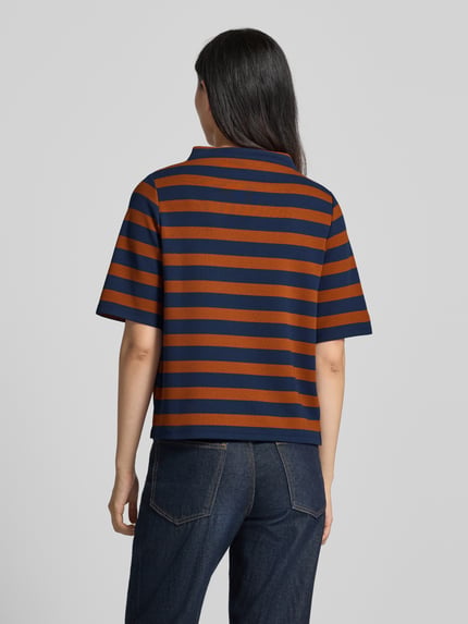 Frauenmodel trägt Relaxed Fit T-Shirt mit Viskose-Anteil von MORE & MORE, braun-blau gestreift, elastisch, Stehkragen, Ganzkörperansicht Rückansicht