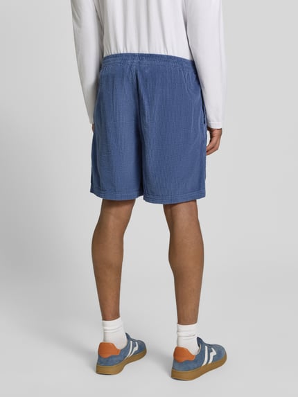 Männermodel trägt Shorts mit elastischem Bund Modell 'PADOW' von American Vintage aus Reine Baumwolle in Loose-Fit, Ganzkörperansicht Rückansicht.