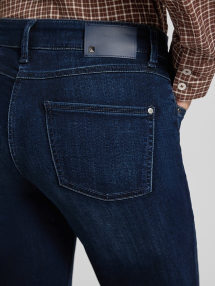 Frauenmodel trägt dunkelblaue Slim Fit Jeans aus Viskose-Mix mit Baumwoll-Modal-Anteil Modell 'POSH' von CAMBIO, Nahaufnahme Rückansicht, Damen Slim Fit Jeans von CAMBIO.
