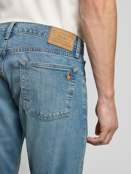 Mężczyzna nosi Slim Fit Jeans mit 5-Pocket-Design od Polo Ralph Lauren, jasnoniebieski denim, bawełna z elastanem, detal z tyłu, zbliżenie.